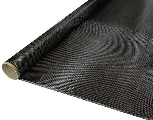 Et nærbillede af Kulfibervæv 160g, almindelig, 100 cm, delvist udrullet for at afsløre den fine gitterstruktur og papkernen - ideel til maritime forsyninger fra boatkitshop.com.
