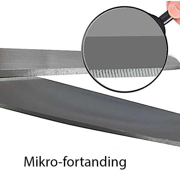 Et nærbillede af "Saks til glas- og kulfiber"-klingen under et forstørrelsesglas afslører fine mikroslibninger (mikrofortanding) langs kanten.