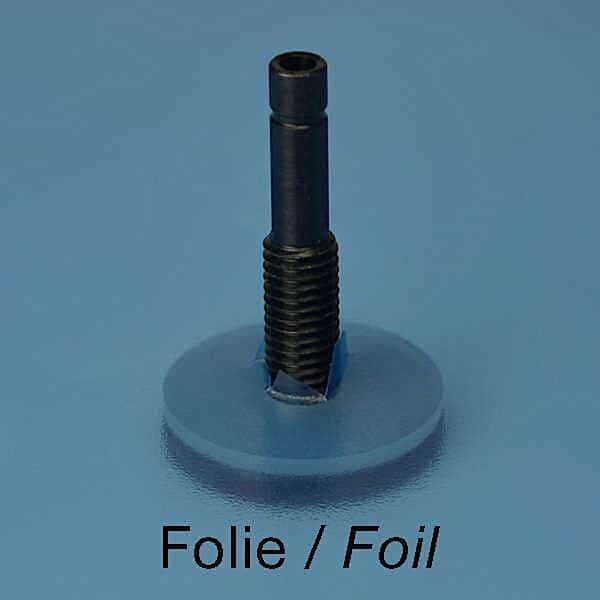 En sort metalstang med gevind (Vakuumstuds 100 °C) står lodret på en gennemskinnelig, cirkulær foliebase mod en blå baggrund. Ordene Folie / Foil vises under objektet.