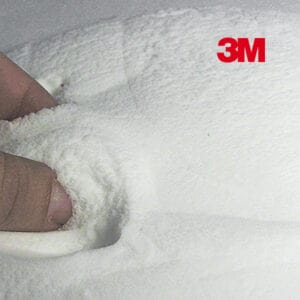 En hånd trykker ind i det bløde, hvide, pudeagtige 3M™ Microballoner-materiale og efterlader et aftryk. Det røde 3M-logo vises i øverste højre hjørne på en hvid baggrund.